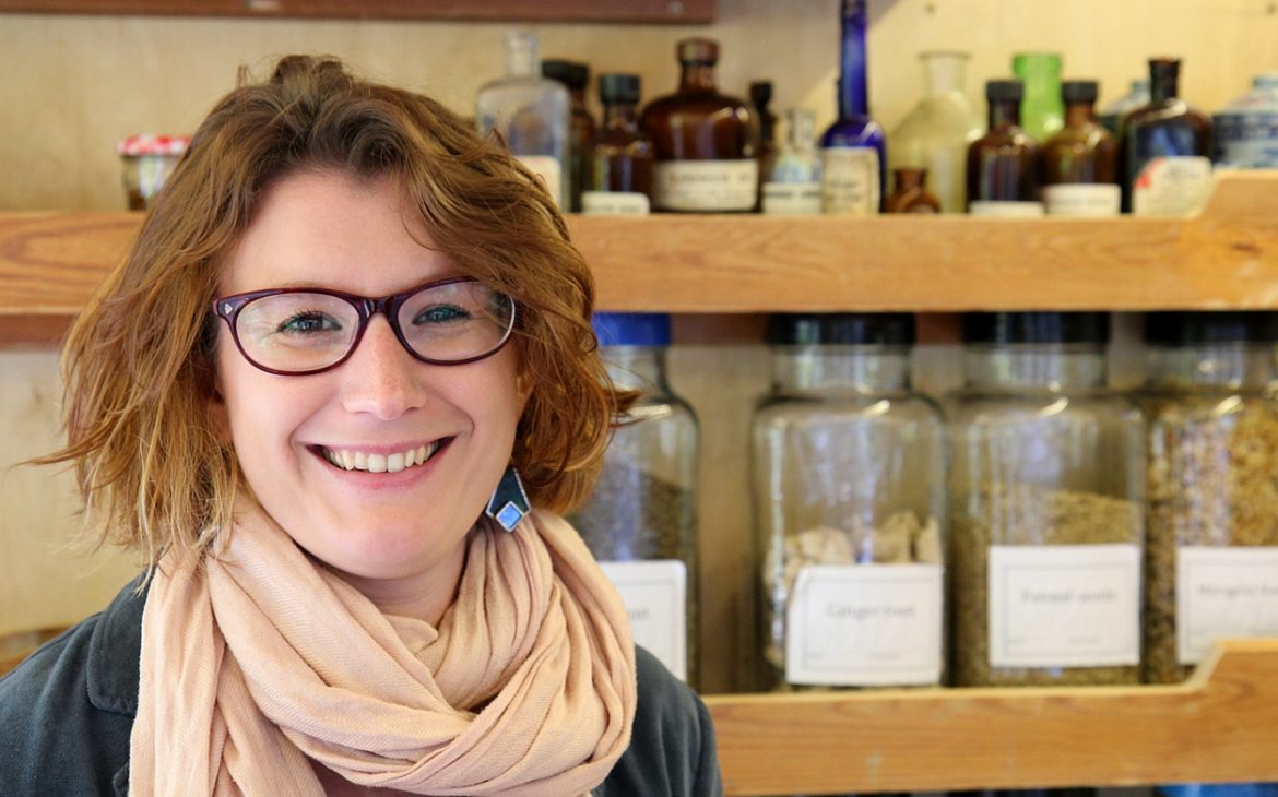 smiling woman in front of shelves of health products