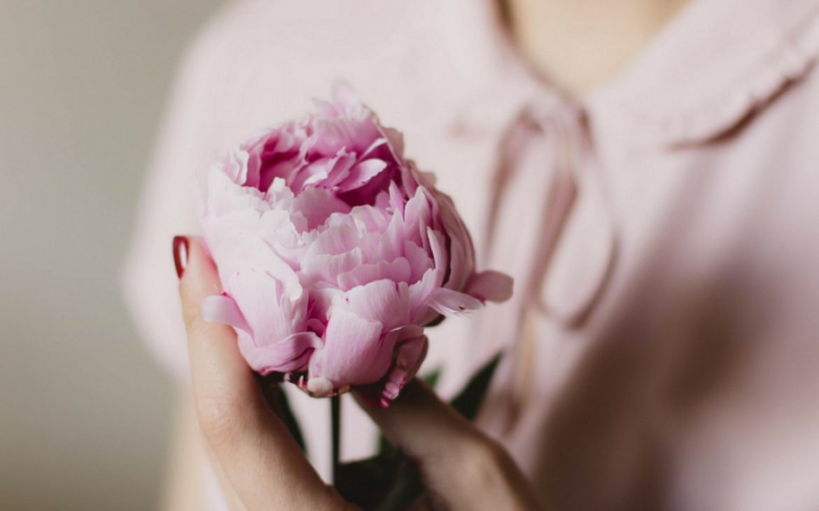 woman practising relaxed breathing techniques holding flower