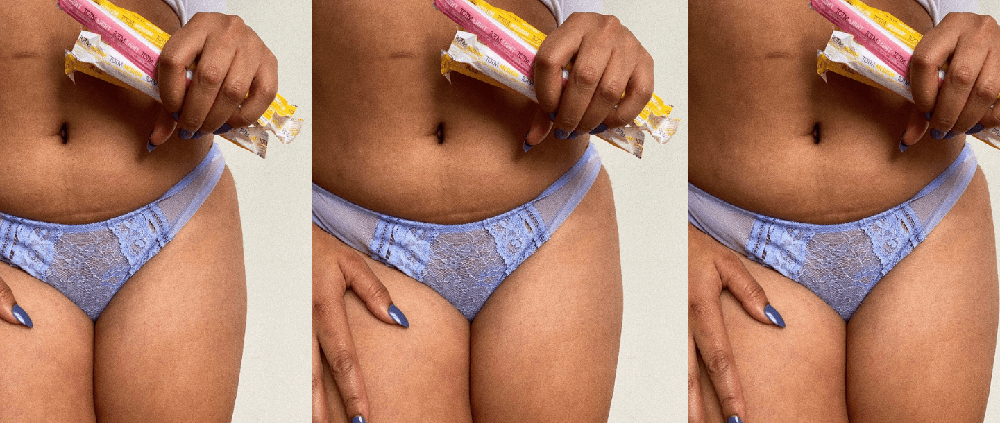 Female PoC holding mix of TOTM organic cotton cardboard applicator tampons in the wrapper